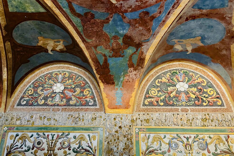 Ruinengrotte: Efeuranken aus Bronze, ursprünglich naturnah bemalt. Das Deckenfresko als ein Ausblick auf den Himmel.