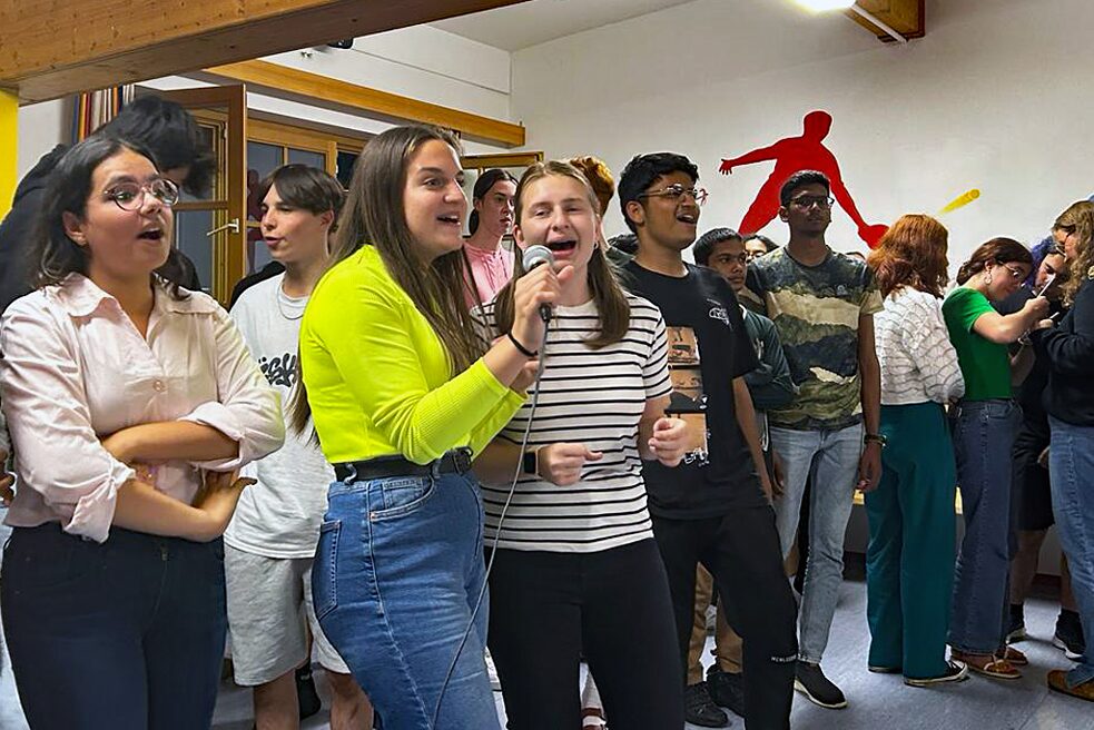 Jugendliche singen in ein Mikrophon.