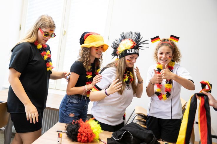 Eine Gruppe Schülerinnen kleidet sich als Deutschlandfans ein.