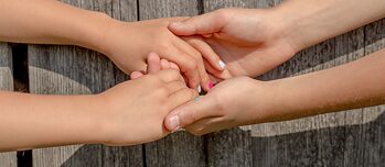 Jugendliche Hände, die sich halten.