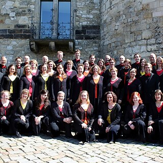 Choir poses in front of old building