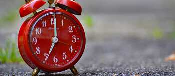Ein roter Wecker steht auf 7:00 Uhr