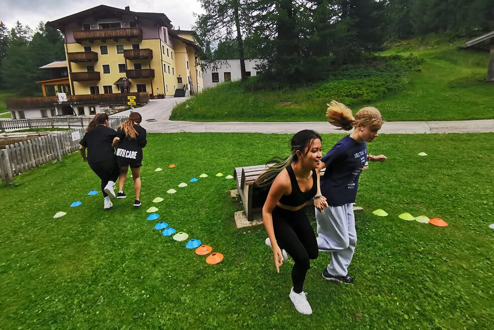 Jugendliche hüpfen auf einer Wiese.