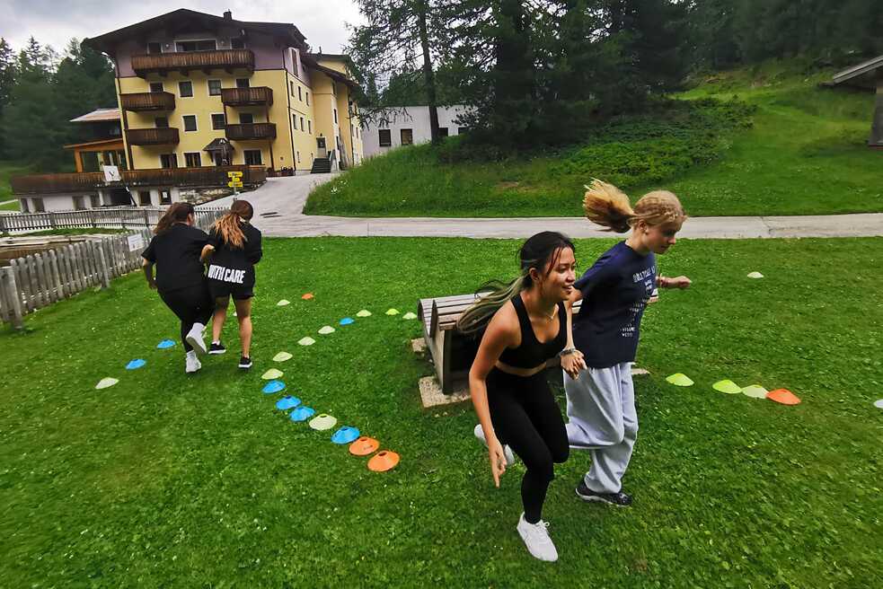 Jugendliche hüpfen auf einer Wiese.