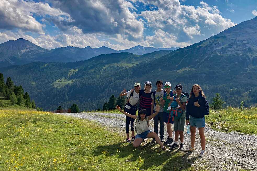 Jugendliche auf einem Wanderweg in den Bergen.