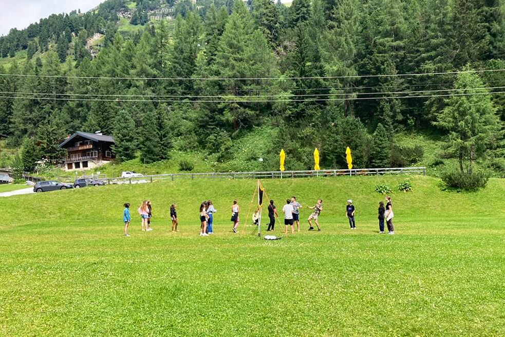 Jugendliche spielen auf einer Wiese.