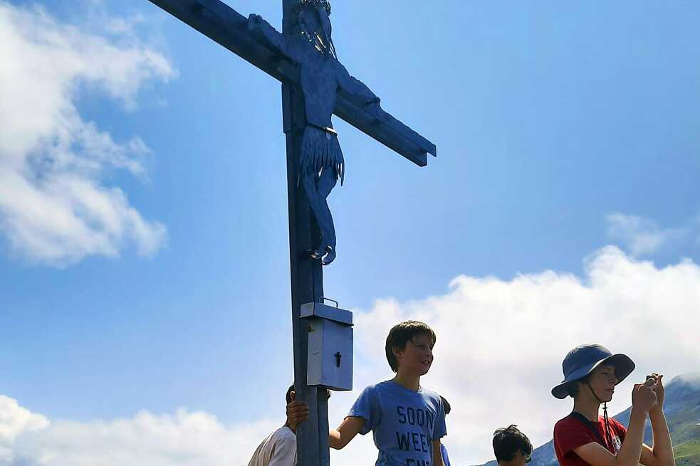 Jugendliche und Bergkreuz.