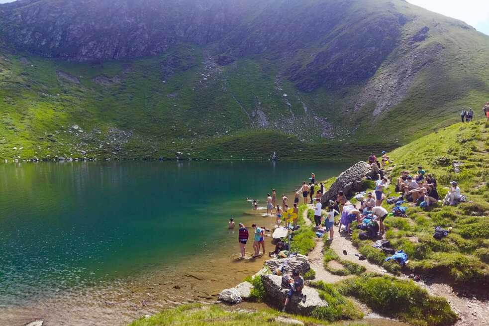Jugendliche an und in einem Bergsee.