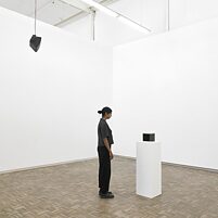 A woman standing in front of Nigerian crude oil as part of the Series of Personal Questions exhibition