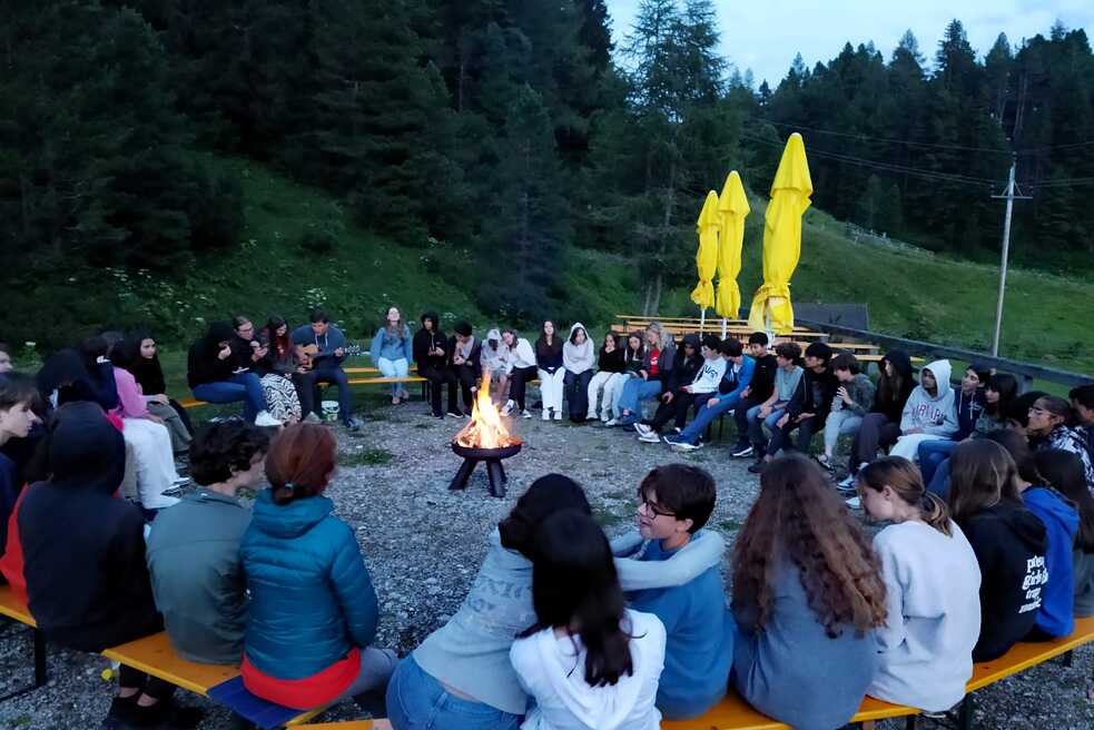Jugendliche um ein Lagerfeuer.