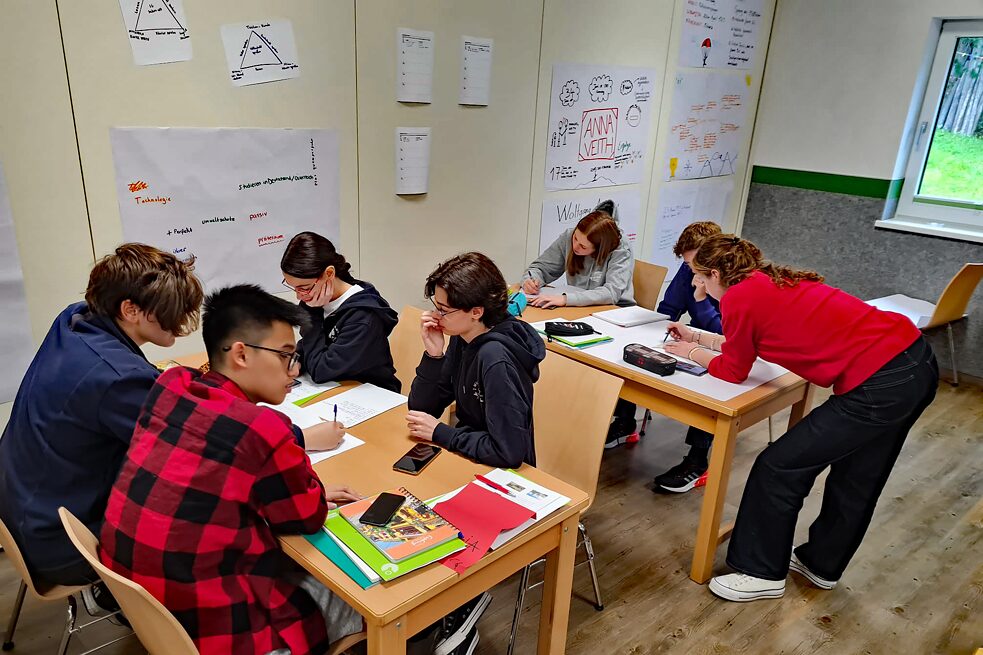 Jugendliche in einem Klassenraum arbeiten konzentriert.