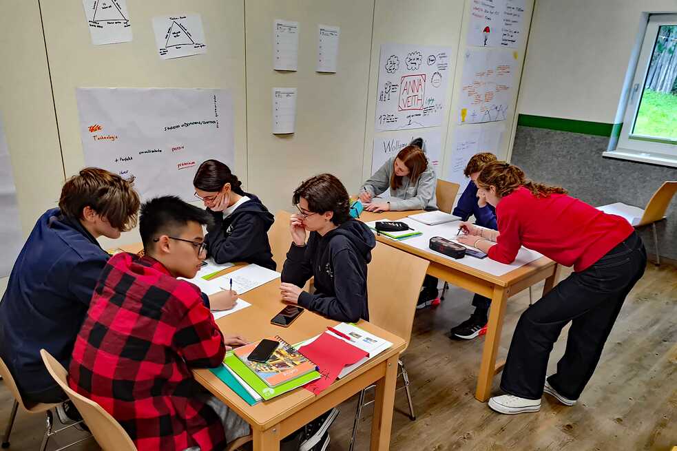 Jugendliche in einem Klassenraum arbeiten konzentriert.