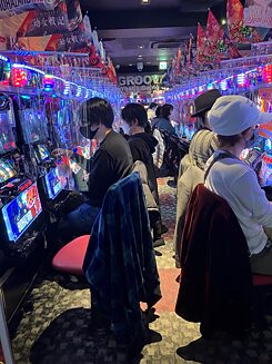Japanese people calmly in the hellish noise of a pachinko-parlour