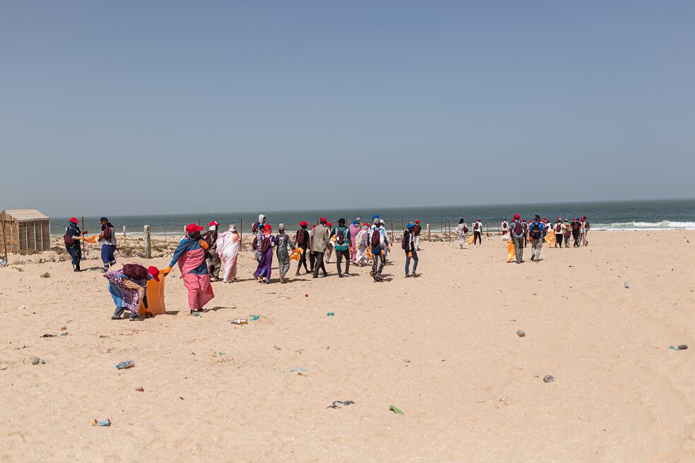 Menschen, die Müll sammeln an einem Strand