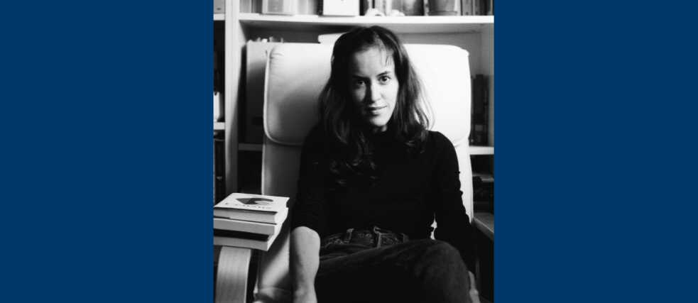 A black and white image of marta sat next to books