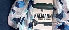 Das Buch 'Kalmann', welches Haie darstellt, liegt auf einem blau-weißen Tuch