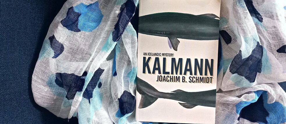 Das Buch 'Kalmann', welches Haie darstellt, liegt auf einem blau-weißen Tuch