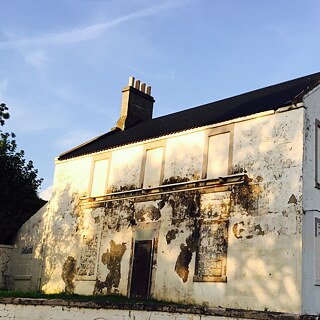 A building with scarred facade sits in bright sunlight