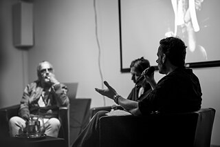 Moderator leads a conversation with artist Sven Marquardt