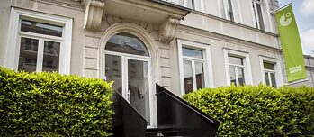 Gebäude hinter einer grünen Hecke 