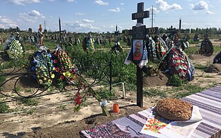 Cintorín v Buči, Kyjevská oblasť, júl 2023: Príbuzní priniesli koláč mŕtvemu mužovi na miesto pre obete ruskej okupácie v roku 2022.