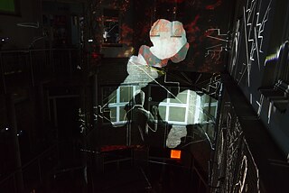 Mit Beamern wurden Bilder auf die Wände des Innenhofes projiziert. Die Zeichnung eines Mannes ist zu sehen und Gebäude, die in Flammen stehen.