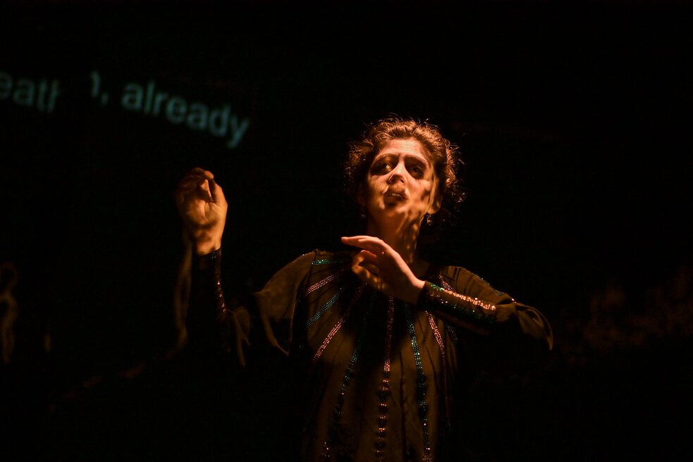 Die angeleuchtete Sängerin Sofia Baskakova ist in Bewegung vor einem schwarzen Hintergrund dargestellt. 