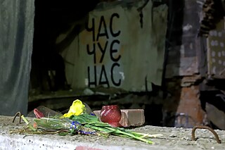 Charkov, máj 2023: „Čas nás počuje“ – charkovský pouličný umelec Gamlet Zinkivskyi (www.instagram.com/gamletzinkivskyi) upravuje budovy zničené ruským ostreľovaním, je tu pamiatkovo chránený mestský dom z roku 1911, v ktorom sa nachádzal obľúbený bar. Ruská raketa ho zničila 14. marca 2022.