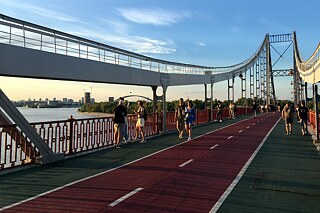Kyjev, júl 2023: Z tohto mosta pre peších cez rieku Dneper si môžete skočiť bungee jumping. Alebo sa len tak pokojne poprechádzať.