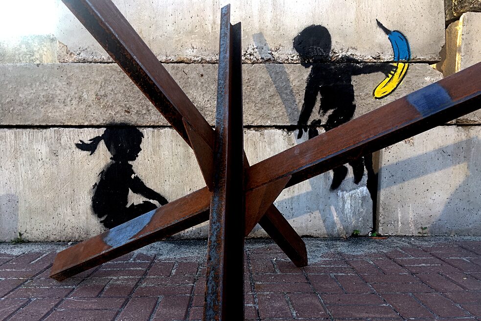 Kyjev, máj 2023: Banksyho grafiti zmenili dnes už nepoužívanú protitankovú zátarasu na detskú hojdačku.