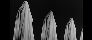 Four figures in white cloths standing at intervals against a black background