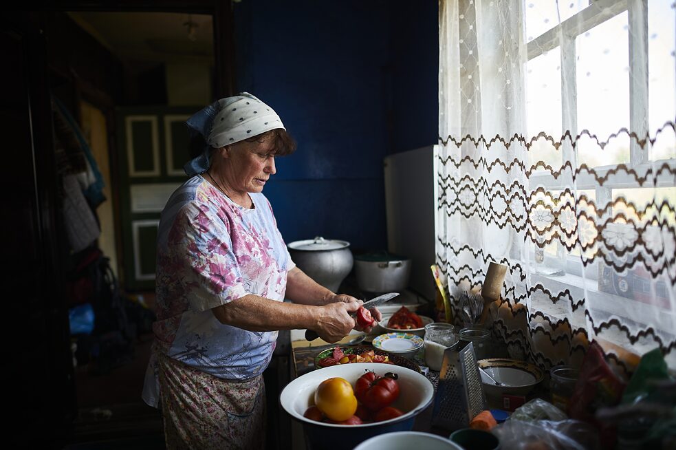 Tamara Leonidovna, majiteľka zhoreného domu, pripravuje obed pre dobrovoľníkov, ktorí stavajú jej dom, zničený pred rokom počas ruskej ofenzívy.
