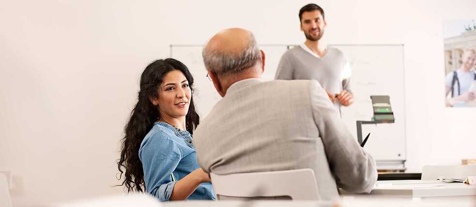 A young woman and an older man engage in a discussion. 