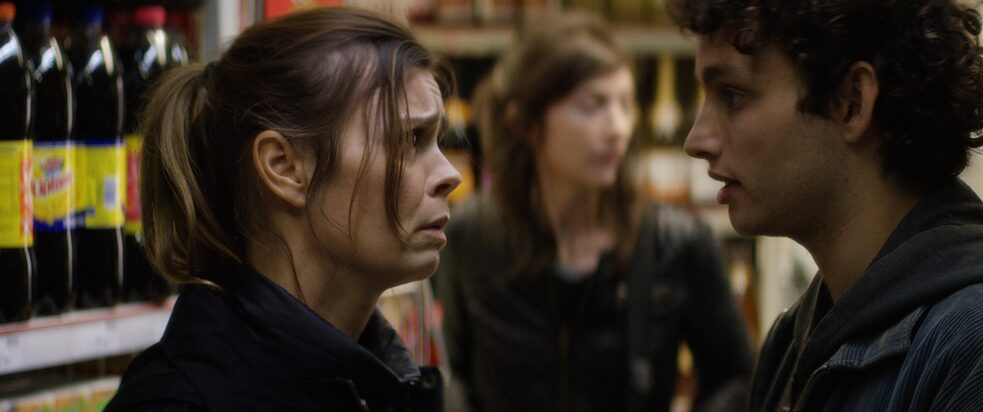 Eine Frau spricht mit einem Mann im Supermarkt. Sie wirkt verzweifelt.