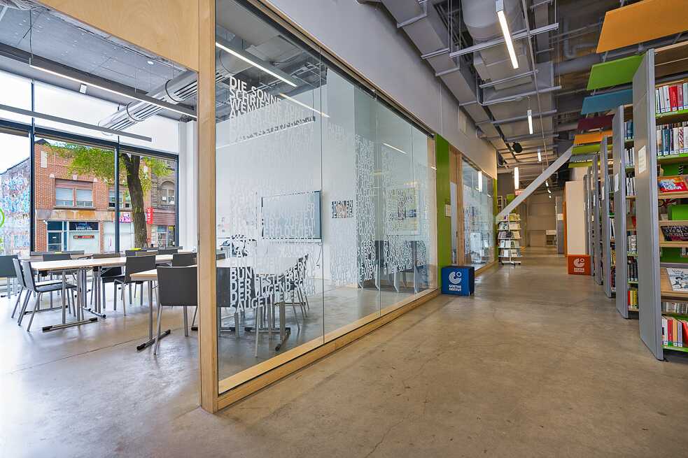  A bright office with a generous open area, complemented by extensive bookshelves that enhance the workspace's functionality.