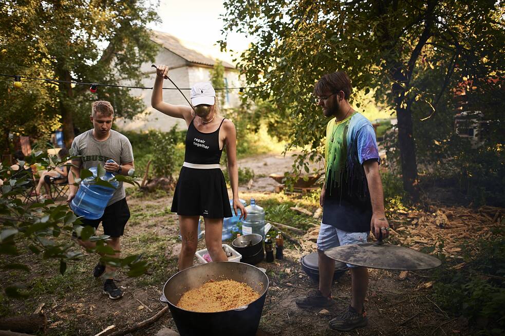 Niektorí dobrovoľníci zostávajú v stanovom tábore, aby pripravili večeru pre ostatných staviteľov.