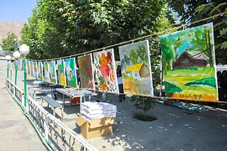 Bilder der Schüler*innen, aufgehängt im Freien