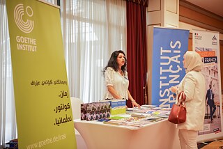 Eine Person berät an einem Deutsch-Französischen Stand