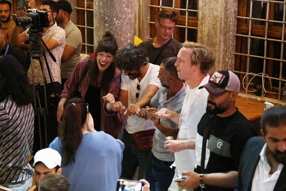 Eine Gruppe Personen feiert ausgelassen während eines Konzerts bei Mosul Music Heritage Festival