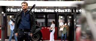 Filmstill aus „Inizio” von Erik Schmidt, ein Mann spaziert die Straße entlang