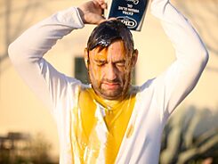 Filmstill aus „Fine” von Erik Schmidt, ein Mann verschüttet Olivenöl auf seinen Kopf