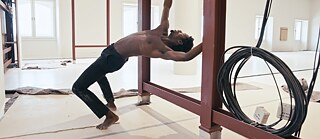 A black man hangs upside down in a dance 