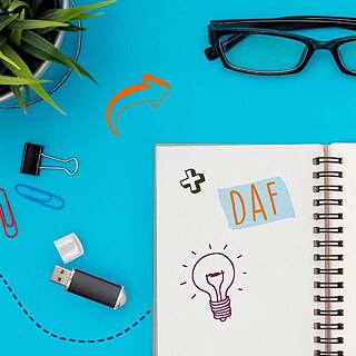 Insegnare il tedesco | Scrivania azzurra con un bloc notes e un paio di occhiali