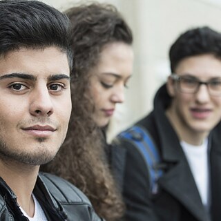 zwei Schüler und eine Schülerin nebeneinander