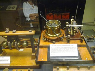 Ein bahnbrechender Radioempfänger, der einen Kohärer, eine Röhre aus Metallspänen, als Detektor verwendet, konstruiert vom italienischen Radioerfinder Guglielmo Marconi im Jahr 1896, ausgestellt im Oxford Museum of the History of Science, UK. Der Kohärent ist die Glasröhre auf der rechten Seite. Wenn er ein Funksignal empfing, läutete er eine Glocke. Dieser Empfänger wurde 1896 bei einer bahnbrechenden Demonstration der Funkkommunikation in der Toynbee Hall verwendet, die Marconi zu einer Berühmtheit machte. Der dazu verwendete Sender (Metallkugeln) ist auf der linken Seite zu sehen.