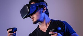 Ein junger Mann mit VR Hardware