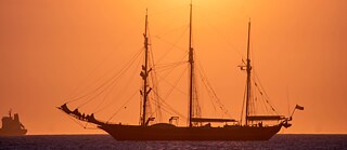 Ein Segelschiff bei Sonnenuntergang