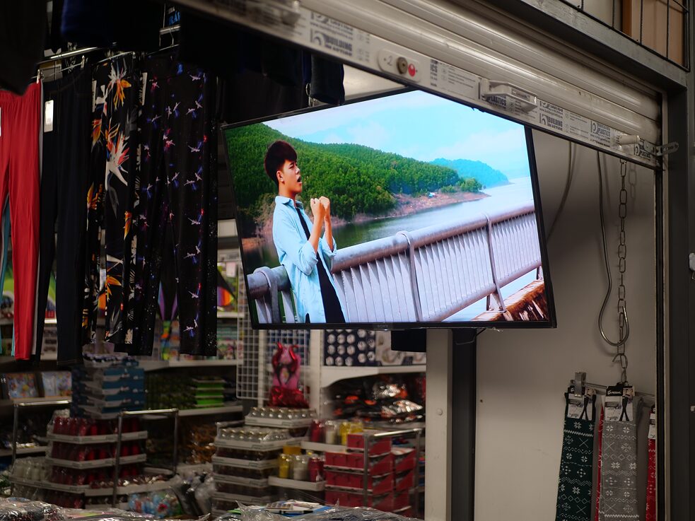 Dlouhé chvíle si prodejci krátí sledováním televizních kanálů – nikoli ale těch českých, jazyková bariéra je u starších Vietnamců stále problémem. Obrazovkám televizorů tak vévodí vietnamské seriály či hudební pořady. 