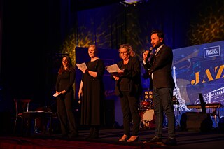 Vier Personen auf der Bühne von Jazz in Erbil, sie halten eine Rede