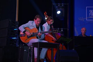 Ein Gitarrist und eine Kontrabassistin auf der Bühne